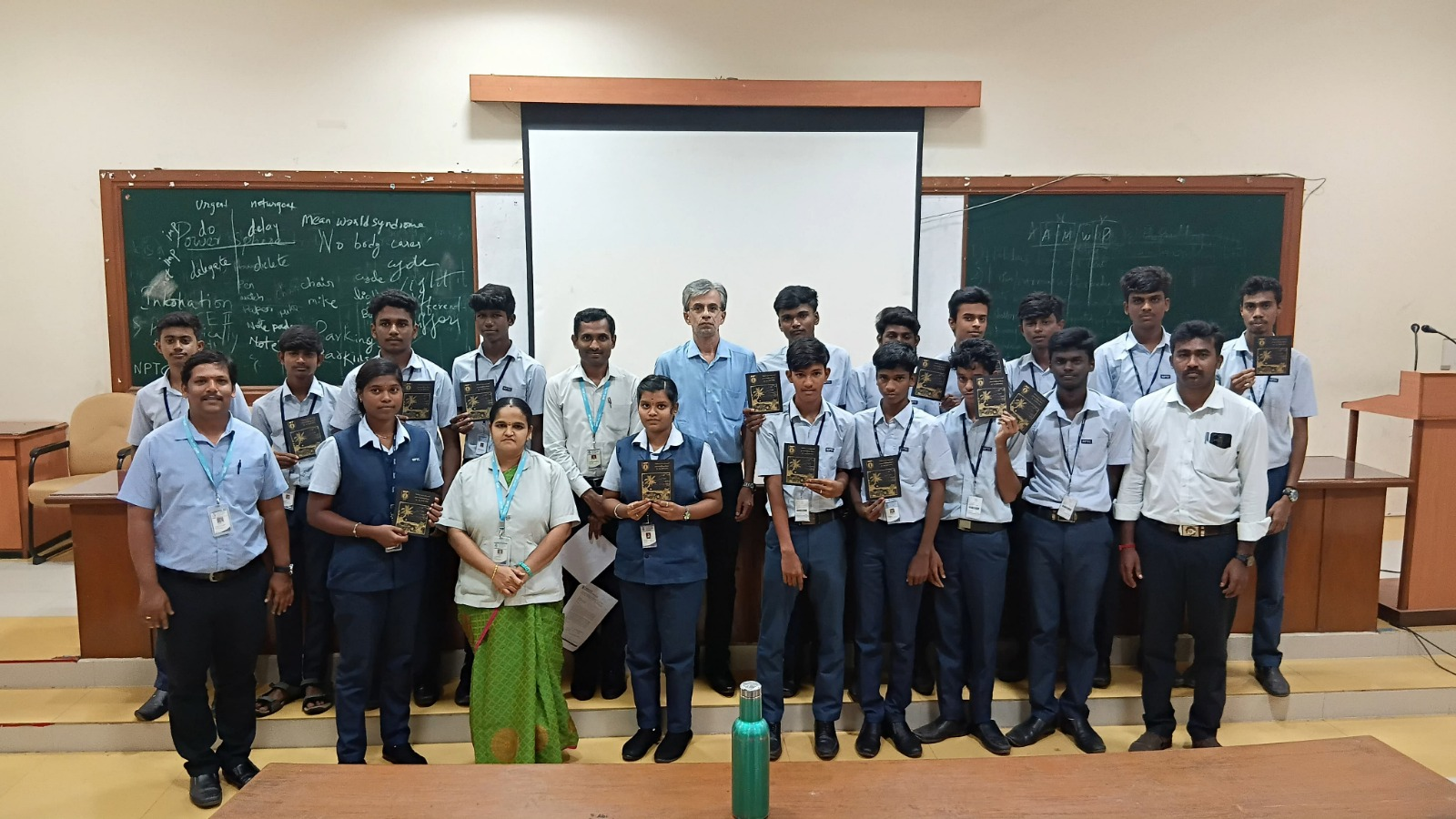 Students and faculty holding freshly printed booklets after a printing workshop